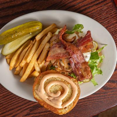 The Animal burger served with pickles and french fries.