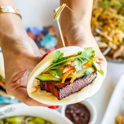 Pork Belly bun in hands, close up