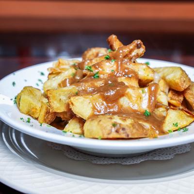 Poutine topped with cheese curds and smothered in a rich brown gravy.