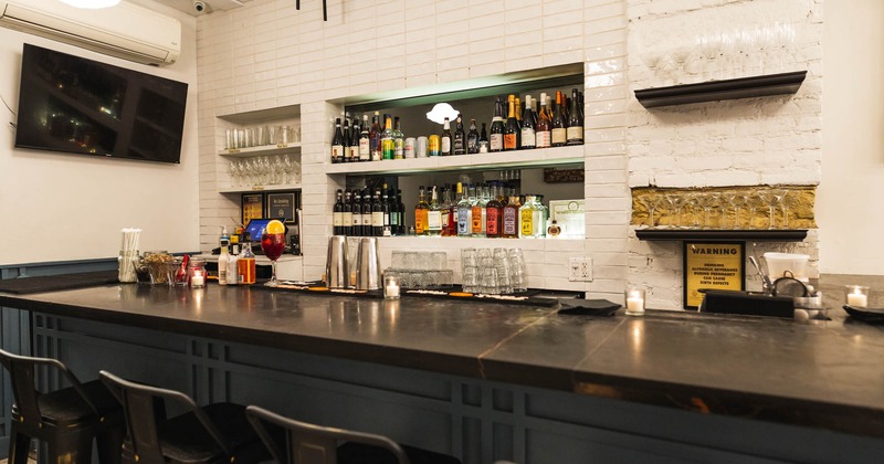 Bar, chairs and wine rack wall behind