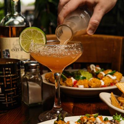 Mystic Paloma cocktail being poured from the bottle with smoke.