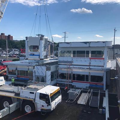 A crane is being used to lift a building off a truck