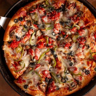 Pizza topped with pepperoni, black olives, green peppers, mushrooms, and cheese.