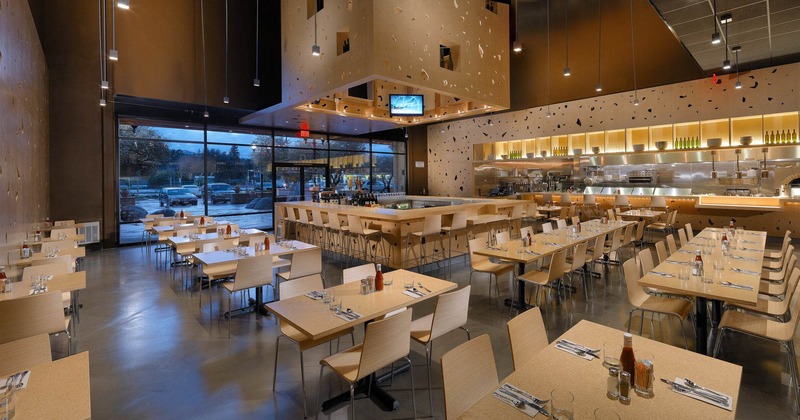 Interior, wide shot of an open space dining area, bar in the middle