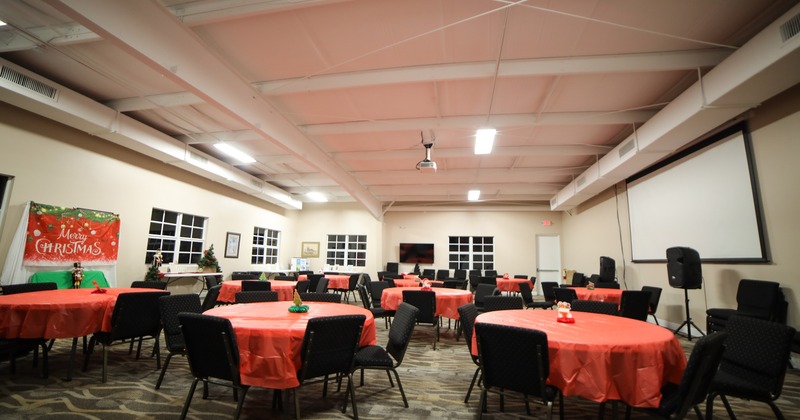 Spacious event hall with round tables, perfect for any private event, from casual to formal