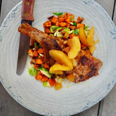 Chicken confit served with a vegetable hash and peach slices.