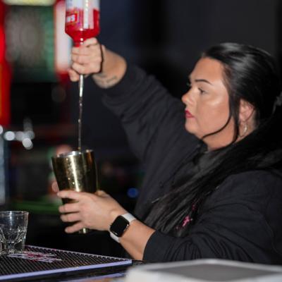 Bartender free pouring from the bottle into the shaker.