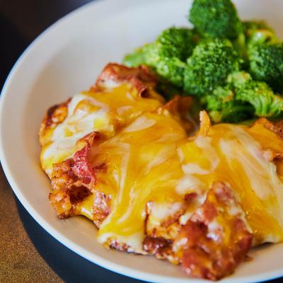 Smothered Chicken with mixed cheese and bacon, side of broccoli.