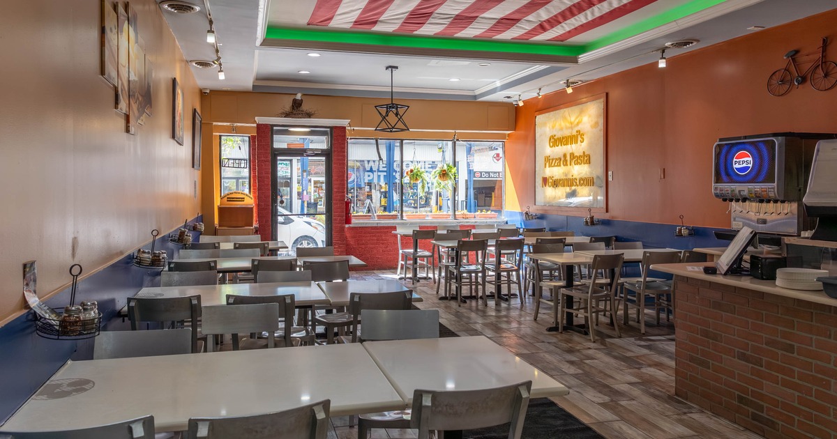 Casual dining interior with tables, chairs and a ceiling-mounted American flag.