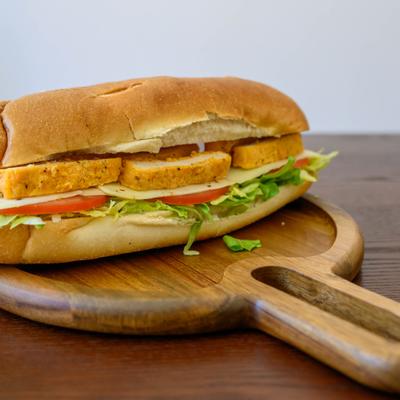 Chicken Cutlet hero served on a wooden board with a handle.