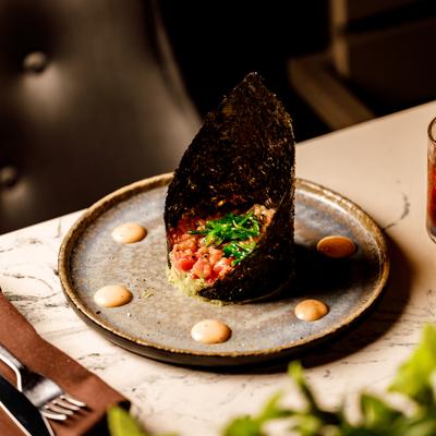 Tuna tartare served over a bed of chopped avocado.