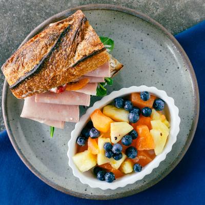 Ham Baguette served with fresh fruit.