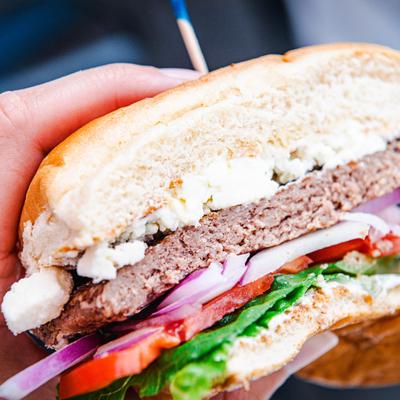 Greek Burger with feta, red onion, tomato, and lettuce.