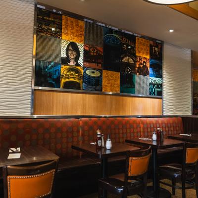 Interior with a mix of booth and table seating and colorful pop-art style mural.