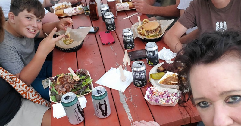 A group of people take a selfie at a table during meal