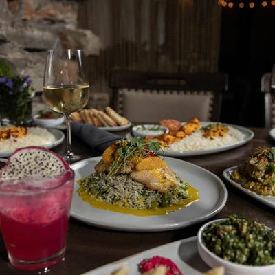 Miscellany of dishes and drinks spread on a table in dining area.