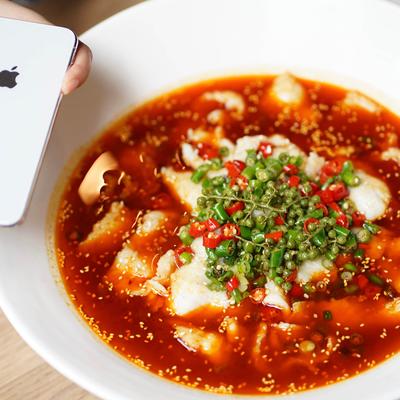 Sichuan boiled fish topped with green peppercorns.