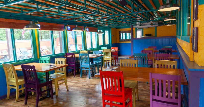 Interior, canopy room, wooden top tables for four, ready for guests