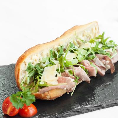 Roast beef, shaved parmesan, and arugula sandwich.