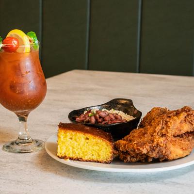 Fried chicken with cornbread and a side of beans served with a Bloody Mary.