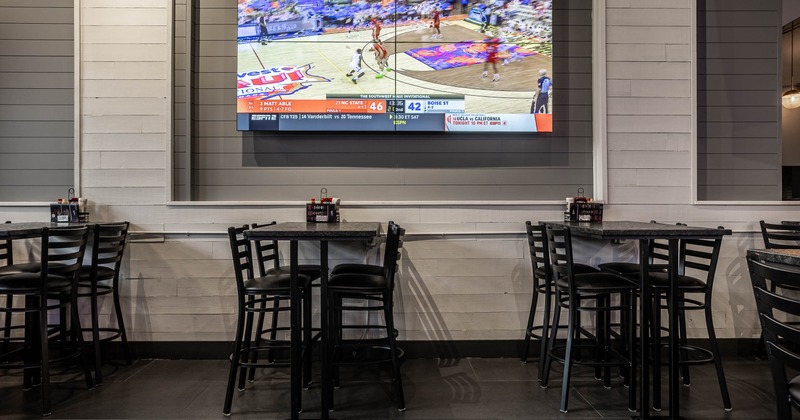 Interior, tables and chairs with TV on the wall