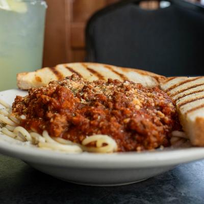 A plate of spaghetti in tomato and meat sauce, served with toast.