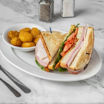 Ham and Turkey club sandwich with golden corn nuggets.