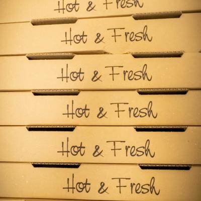 Stacked Hot and Fresh pizza boxes.
