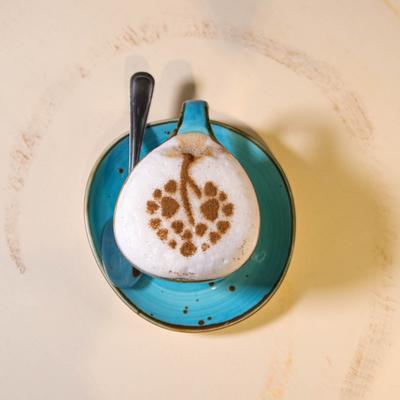 A cup of cappuccino decorated with cinnamon on a blue saucer.