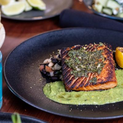 Grilled salmon over green puree with fresh bean salad on the side.