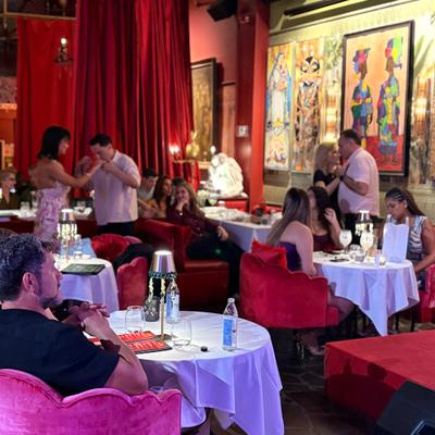 People seated having dinner while others dance in the back.