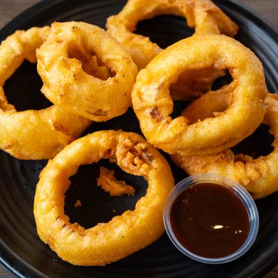 Jumbo onion rings served with a dipping sauce.
