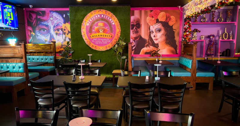 Interior of a Mexican restaurant with Day of the Dead murals and turquoise seating