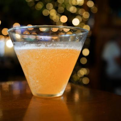 Orange cocktail in a clear martini glass.