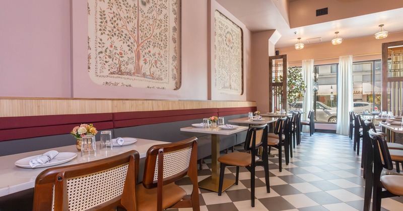 Elegant interior - pink walls, large botanical art, checkered flooring and cane-back chairs