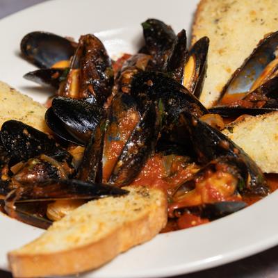 Mussels in tomato sauce, served with toasted bread.