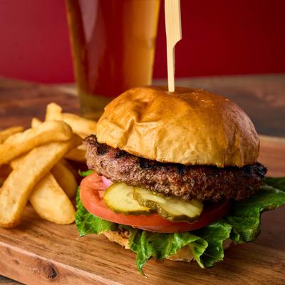 Burger with lettuce, tomato, and pickles, served with fries.