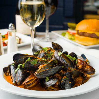 Mussels in marinara sauce, garnished with fresh herbs.
