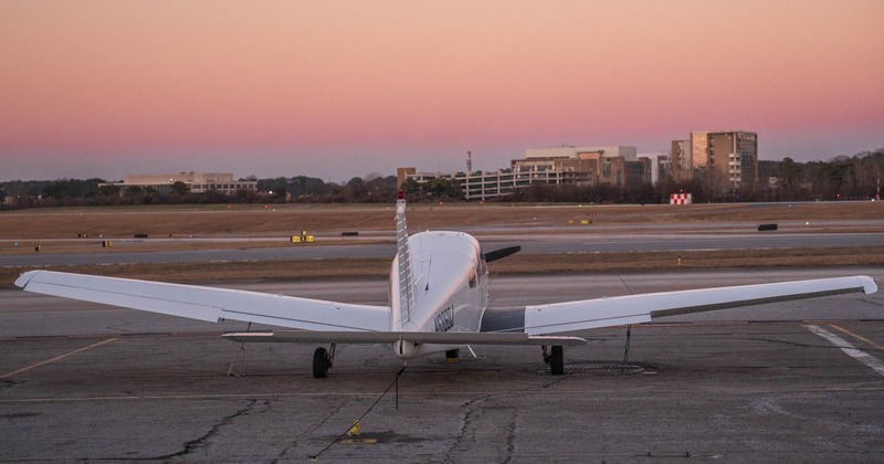 Light aircraft parked on an airport apron during sunset