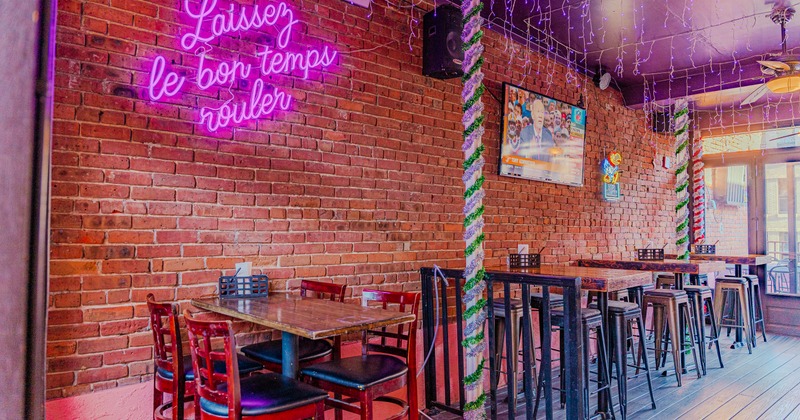 Interior, brick wall with neon sign, bar tables and stools