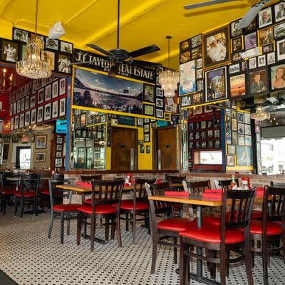 Interior with chandeliers, photos on the walls, tables, and chairs.