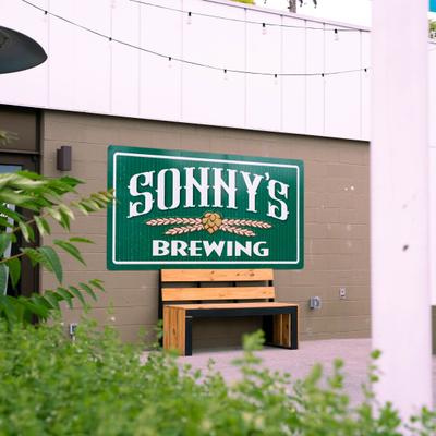Sonny's Brewing sign above a bench.