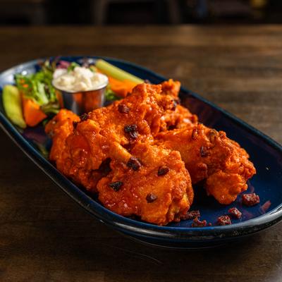 Spicy chicken wings with celery, carrots, and ranch.