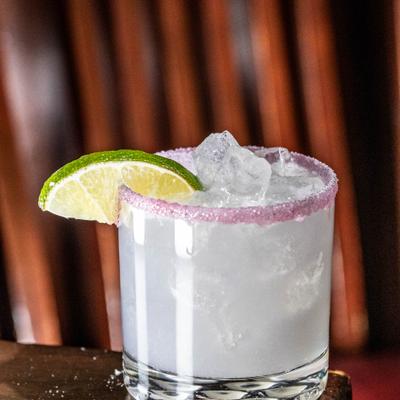 Coconut Lavander Martini in rimmed rocks glass, garnished with lime slice.