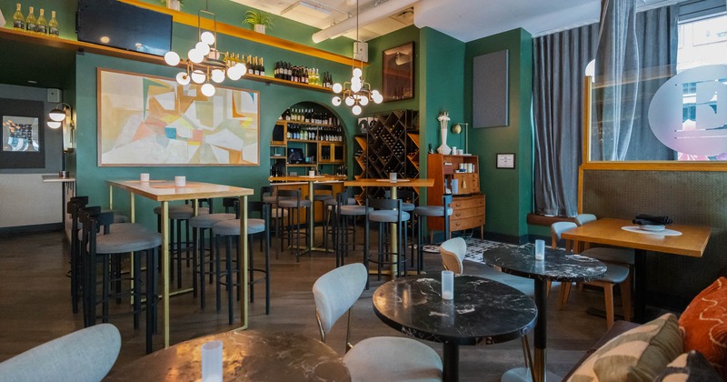 Interior with high-top seating and assorted wine bottles on the racks and shelves