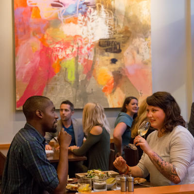 Bar area filled with people enjoying drinks, food and good conversation