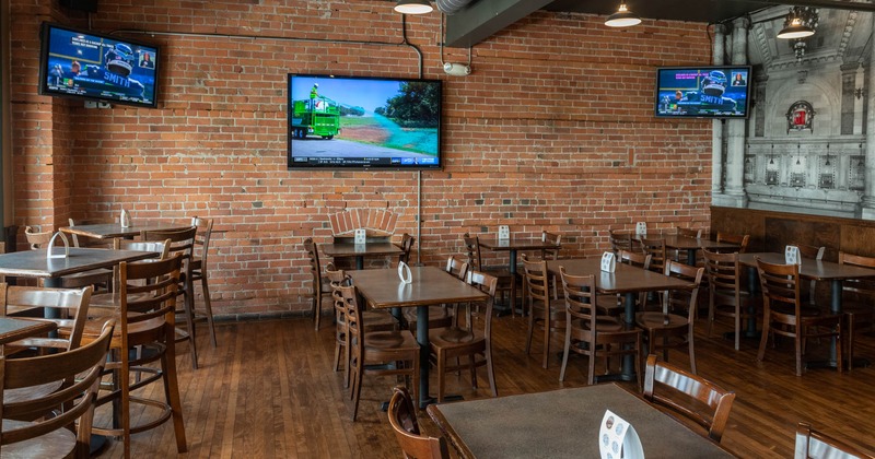 Interior, dining tables, TVs on a brick wall
