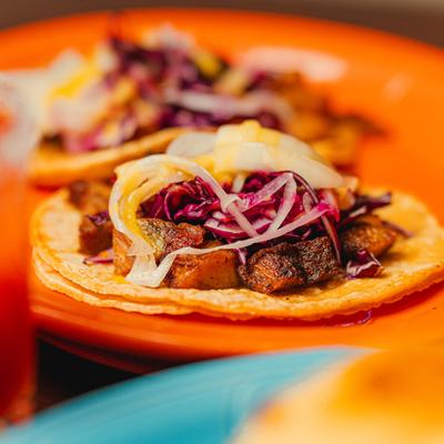 Close-up of a pork belly taco with shredded cabbage.