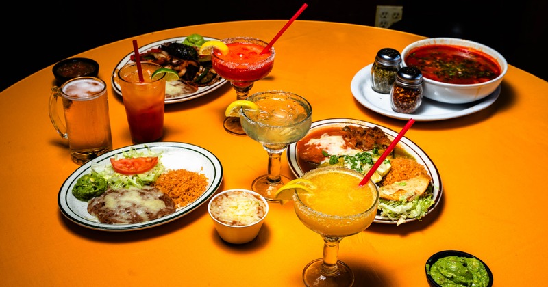 Mexican dishes and colorful cocktails covering a table