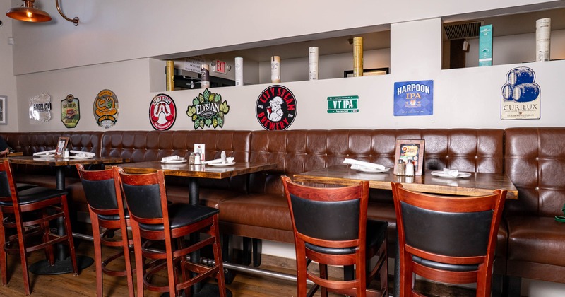 Restaurant interior with booths, tables, and beer logos on the wall